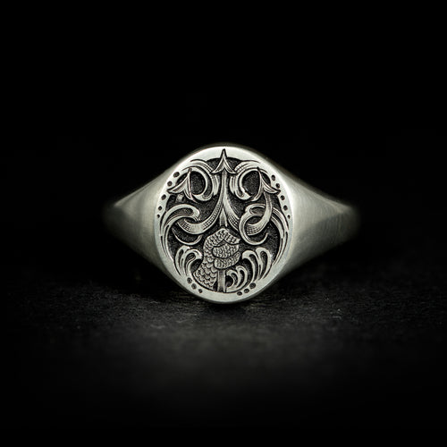 Silver oval jewellery signet ring hand engraved with fantasy scene of Poseidon thrusting his trident from the water. On black background face on.